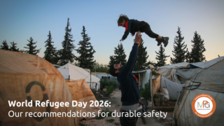 A father playfully throws his young child up in the air in a refugee camp.