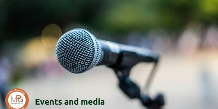 A zoomed-in photo of microphone against a diffused background suggesting a dynamic outside environment. The MPG logo and the words "Events and media" are superimposed in the lower left corner.